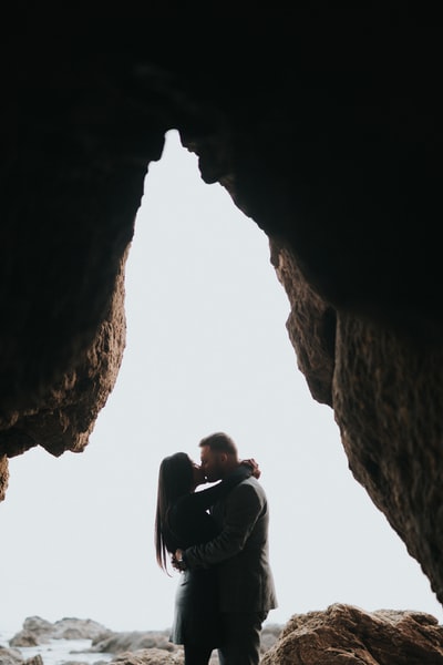 女人和男人亲吻在洞穴入口
